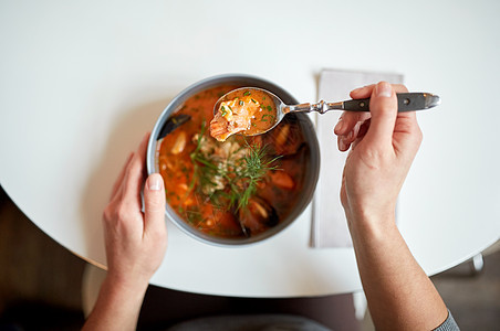 食物,新北欧美食人们的女人吃海鲜汤与鱼蓝色贻贝咖啡馆餐馆背景图片
