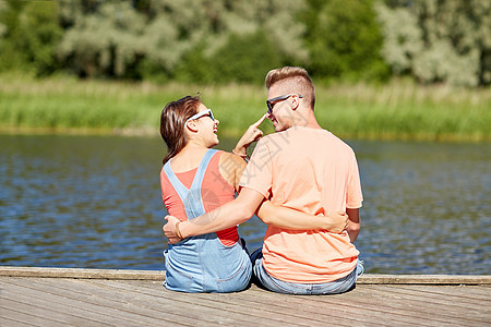 假期,爱人的快乐的十几岁的夫妇坐河泊夏天拥抱图片