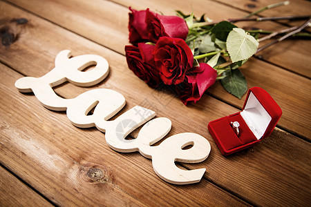 求婚,浪漫,情人节假日礼品盒与钻石订婚戒指,红玫瑰字爱的木材复古效果图片