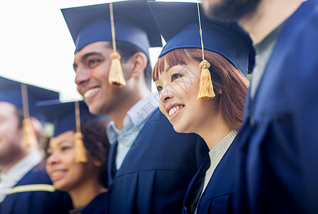 教育,毕业人的群快乐的国际学生砂浆板学士学位礼服户外图片