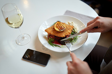 食物,新北欧美食人们的女人与智能手机吃包鱼片与酒石酱烤箱烤甜菜根番茄沙拉与叉子刀咖啡馆餐馆图片