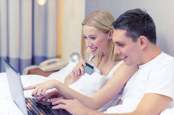 酒店,旅游,关系,技术,互联网幸福的微笑的夫妇床上笔记本电脑信用卡图片