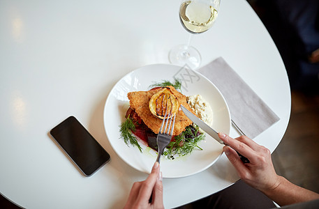 食物,新北欧美食人们的女人与智能手机吃包鱼片与酒石酱烤箱烤甜菜根番茄沙拉与叉子刀咖啡馆餐馆图片