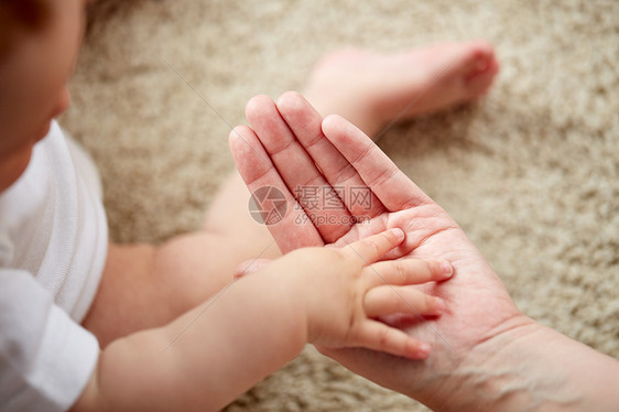 家庭,慈善人的亲密的小婴儿母亲的手把小宝宝妈妈的手关来图片