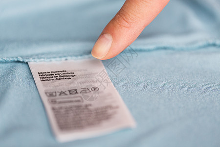 衣服,洗衣,人管家的手指指向标签与用户手册上的服装项目手指指向用户手册的服装图片