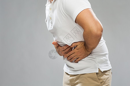 人保健健康问题的灰色背景下密切灰色背景密切关注患胃痛的人图片