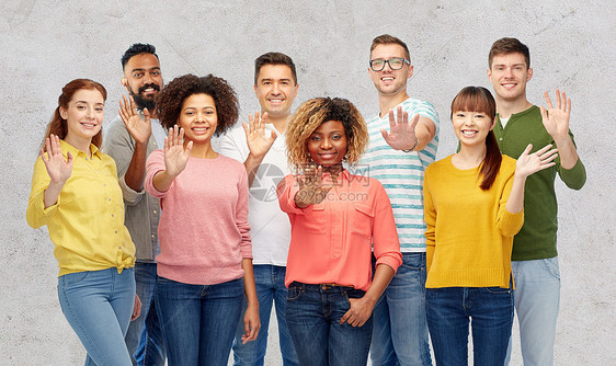 多样种族族裔人的国际上群快乐微笑的男人女人灰色的混凝土背景上挥手国际上群快乐的人挥手图片