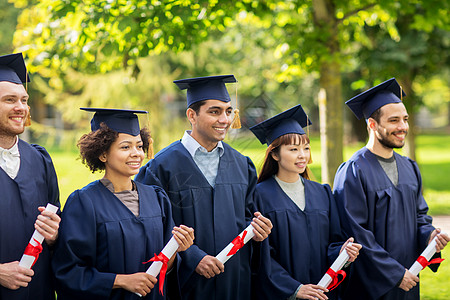 教育,毕业人的群快乐的国际学生迫击炮板学士学位礼服与文凭文凭的迫击炮板上快乐的学生图片