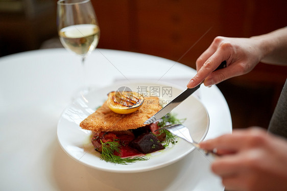 食物,新北欧美食人们的女人吃包鱼片与酒石酱烤箱烤甜菜根番茄沙拉与叉子刀咖啡馆餐馆女人咖啡馆餐馆吃鱼沙拉图片