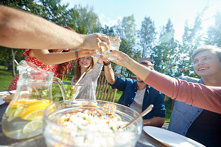 休闲,假期,饮食,人食物的快乐的朋友夏季花园聚会上吃晚饭叮当的饮料快乐的朋友夏天的花园聚会上喝酒图片