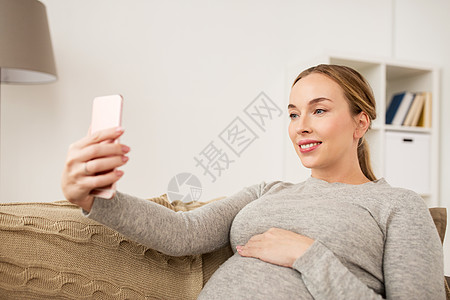 怀孕,母,技术,人期望快乐的孕妇与智能手机家里自拍孕妇家里拍智能手机自拍图片