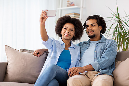 家庭,技术人的幸福的夫妇与智能手机家里自拍幸福的夫妇与智能手机家里自拍图片