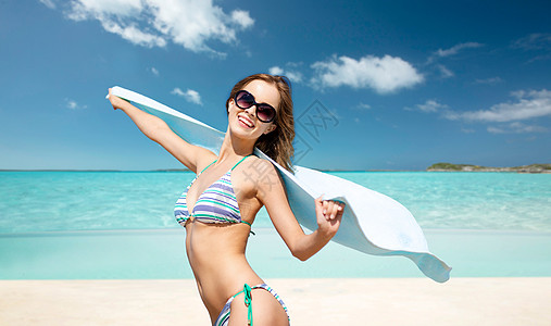 人们,暑假假期美丽的女人穿着比基尼太阳镜带毛巾异国情调的热带海滩背景穿着比基尼太阳镜的女人海滩上毛巾图片