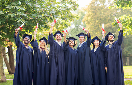 教育毕业人的群快乐的国际学生穿着灰浆板学士服,毕业证书庆祝成功文凭的迫击炮板上快乐的学生黑色高清图片素材