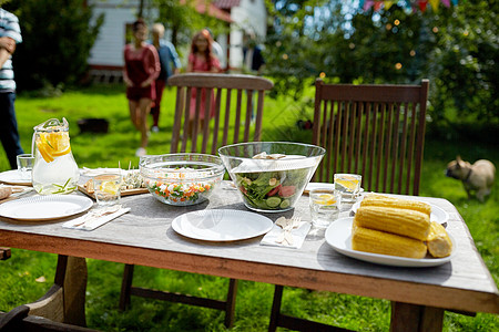 假期,饮食,用餐时间食物人们来提供桌子与晚餐夏季花园聚会人们夏天的花园里带着食物来吃饭图片