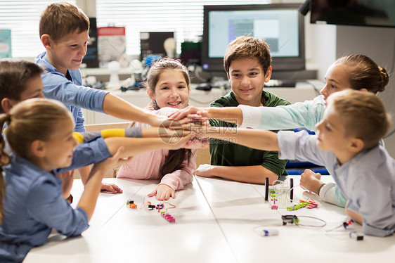 教育,儿童,技术,科学人的群快乐的孩子机器人课上建造机器人,并手拉手快乐的孩子机器人学校牵手图片