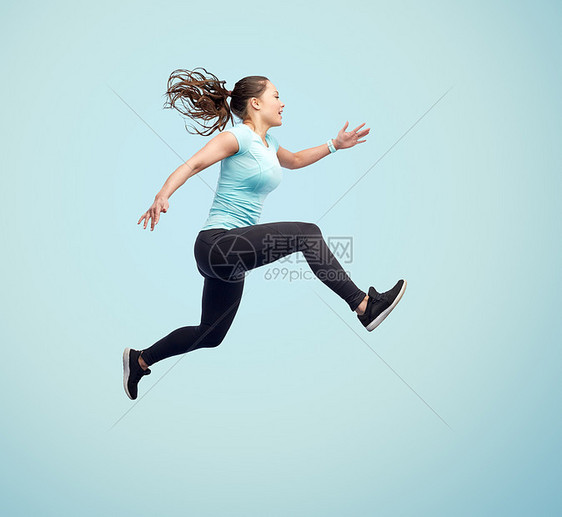运动,健身,运动人们的快乐的微笑轻女人蓝色背景上跳跃快乐微笑运动的轻女人空中跳跃图片