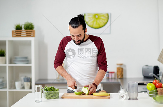 健康饮食,素食,饮食人的快乐的轻人与搅拌机水果烹饪家里厨房家里厨房里搅拌机水果烹饪的男人图片