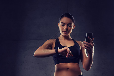体育,健身,技术人的轻的女人与心率手表智能手机健身房健身房里心率手表智能手机的女人图片