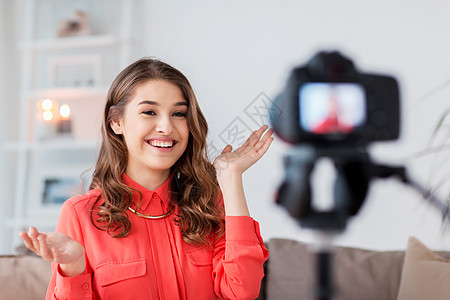 博客,技术,视频博客,大众媒体人的快乐的微笑女人博客与相机录制视频家里家里摄像机录像的女人图片