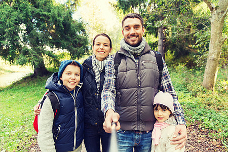 技术,旅游,徒步旅行人们的快乐的家庭与背包拍照自拍棒徒步旅行带背包的家庭自拍徒步旅行图片