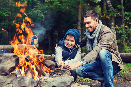 野营,旅游,远足,家庭人的快乐的父亲儿子烤棉花糖超过篝火父子俩篝火上烤棉花糖图片
