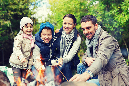 野营,旅游,徒步旅行人们的快乐的家庭烤棉花糖超过篝火快乐的家庭烤棉花糖超过篝火图片