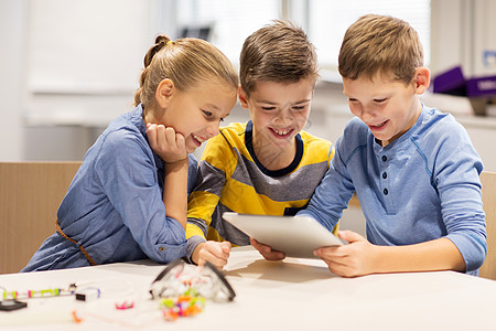 一群快乐的孩子围在一起看平板电脑图片