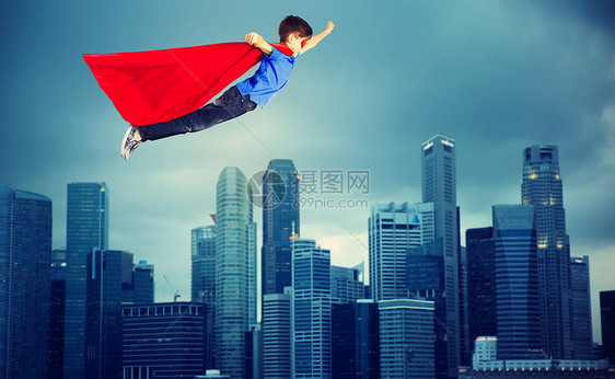 幸福,自由,童,运动人的男孩穿着红色超级英雄斗篷具城市背景上空飞行穿着红色超级英雄斗篷的男孩飞过城市图片