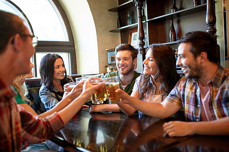 人,休闲,友谊庆祝的快乐的朋友酒吧酒吧喝生啤酒碰杯快乐的朋友酒吧酒吧喝啤酒图片