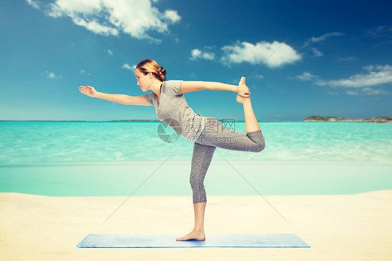健身,运动,人健康的生活方式妇女瑜伽的主舞姿势垫子上的海洋天空背景女人瑜伽的主舞姿势图片