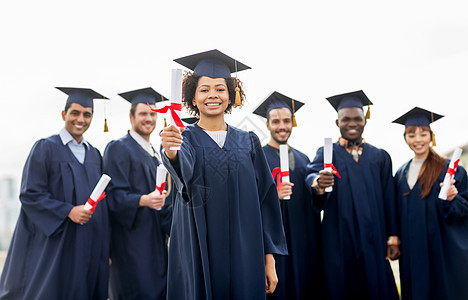 教育,毕业人的群快乐的国际学生迫击炮板学士学位礼服与文凭文凭的迫击炮板上快乐的学生图片