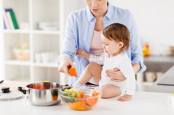 家庭,食物,健康饮食,烹饪人的快乐的母亲小女婴与蔬菜锅家里厨房快乐的母亲婴儿家煮蔬菜图片
