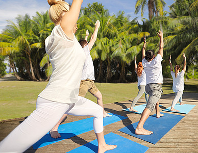 健身,运动,瑜伽健康的生活方式群人自然背景下用棕榈树高弓步新月姿势群人户外瑜伽练图片
