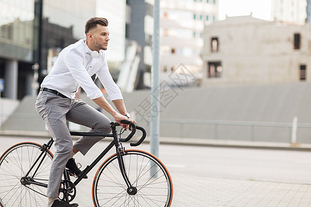 生活方式,交通人们的轻人戴着耳机骑自行车城市街道戴着耳机的男人城市街道骑自行车图片