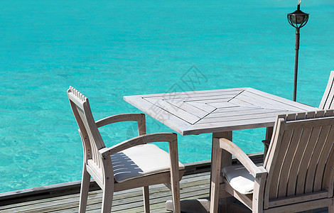 旅游,度假暑假的户外餐厅木制露台与桌子椅子的海洋背景海上的餐厅露台上的桌子椅子图片