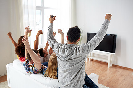 友谊,假期人们的快乐的朋友家里看电视喝啤酒快乐的朋友家里喝啤酒看电视图片