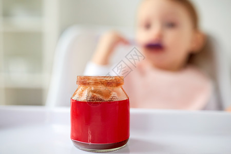 孩子,喂养人的婴儿食品罐家里的桌子上家里桌子上罐婴儿食品图片