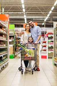 销售,消费主义人们的幸福的家庭与孩子购物车购买食品杂货店超市杂货店购物车里食物的家庭图片