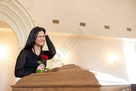 葬礼,人们哀悼的哭泣的快乐的女人与红玫瑰棺材教堂的葬礼上带着红玫瑰棺材葬礼上哭泣的女人图片