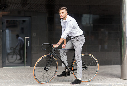 生活方式,交通人们的轻人骑自行车耳机城市街道城市街道上自行车耳机的男人图片
