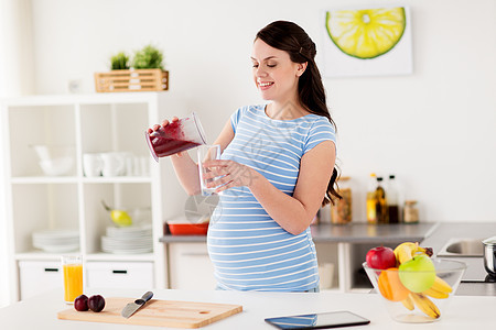 健康的饮食,烹饪,怀孕人的孕妇用搅拌机杯倒水果冰沙饮料家里厨房的璃孕妇家里搅拌机杯璃图片