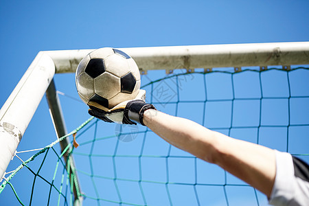体育人足球运动员守门员蓝天上的足球球门手接球守门员天空上的足球进球背景图片