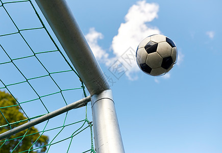 体育,足球比赛球飞足球球门网蓝天上足球空中飞进足球球门网图片