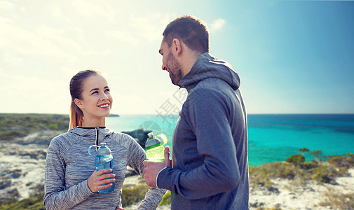 健身,运动,人生活方式的微笑夫妇与瓶水户外微笑的夫妇瓶子的水户外图片