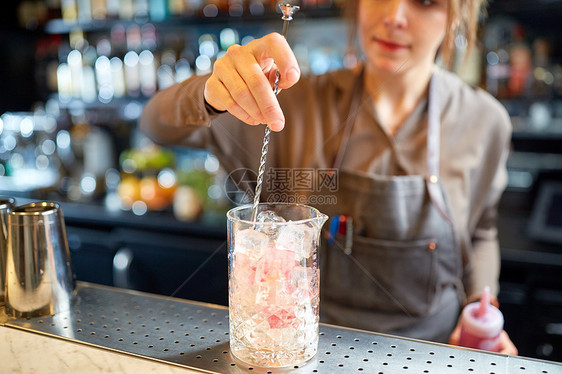 酒精饮料,人豪华女调酒师与搅拌器杯冰准备鸡尾酒酒吧柜台酒吧里鸡尾酒搅拌器璃杯的酒保图片