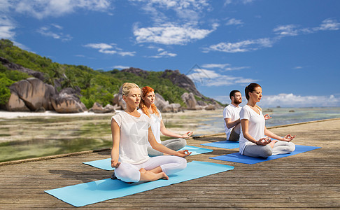 健身,运动,瑜伽健康的生活方式群人异国情调的热带海滩背景下冥想莲花姿势人们户外冥想瑜伽莲花姿势图片