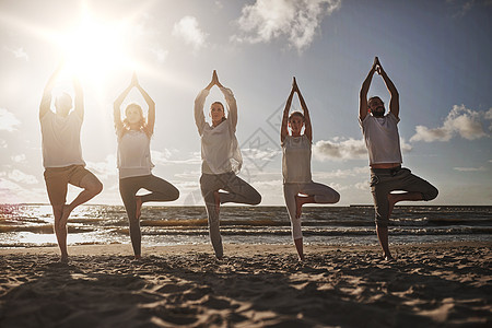 瑜伽,健身,运动健康的生活方式群人海滩上的树姿势群人海滩上树姿势瑜伽图片