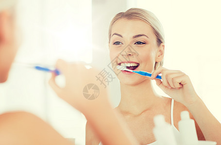 保健,牙科卫生,人与美的微笑的轻妇女牙刷,清洁牙齿,并家里的浴室看镜子牙刷的女人浴室刷牙图片