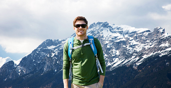 旅游,旅游人的快乐的轻人戴着太阳镜,背包阿尔卑斯山的背景快乐的人背包旅行高地图片